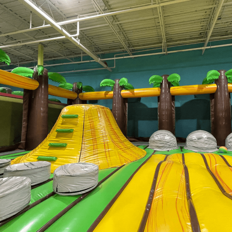 Inside tiki themed inflatable obstacle course in private party gym.