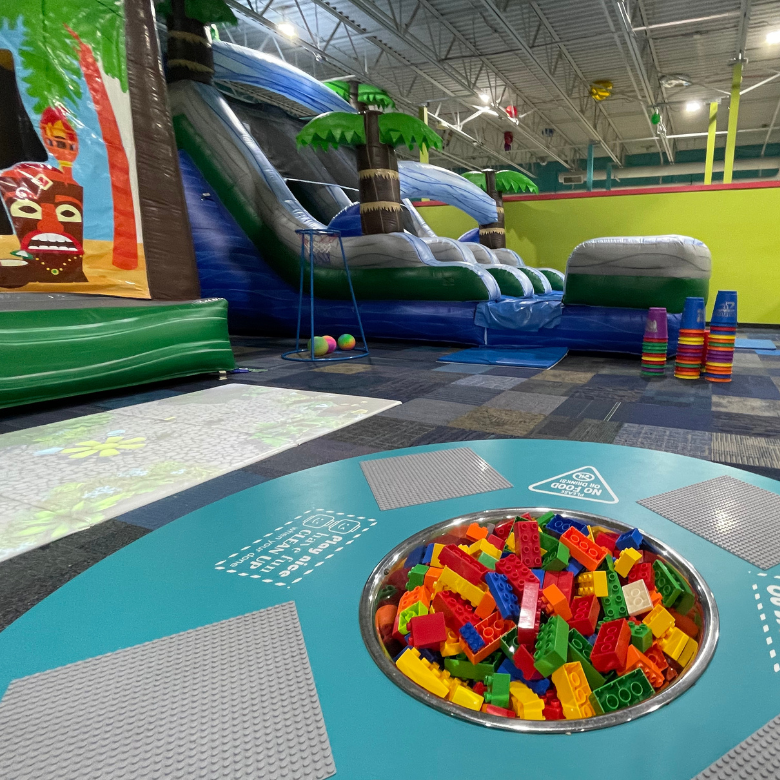 Kid sized lego table with colorful inflatables in the background