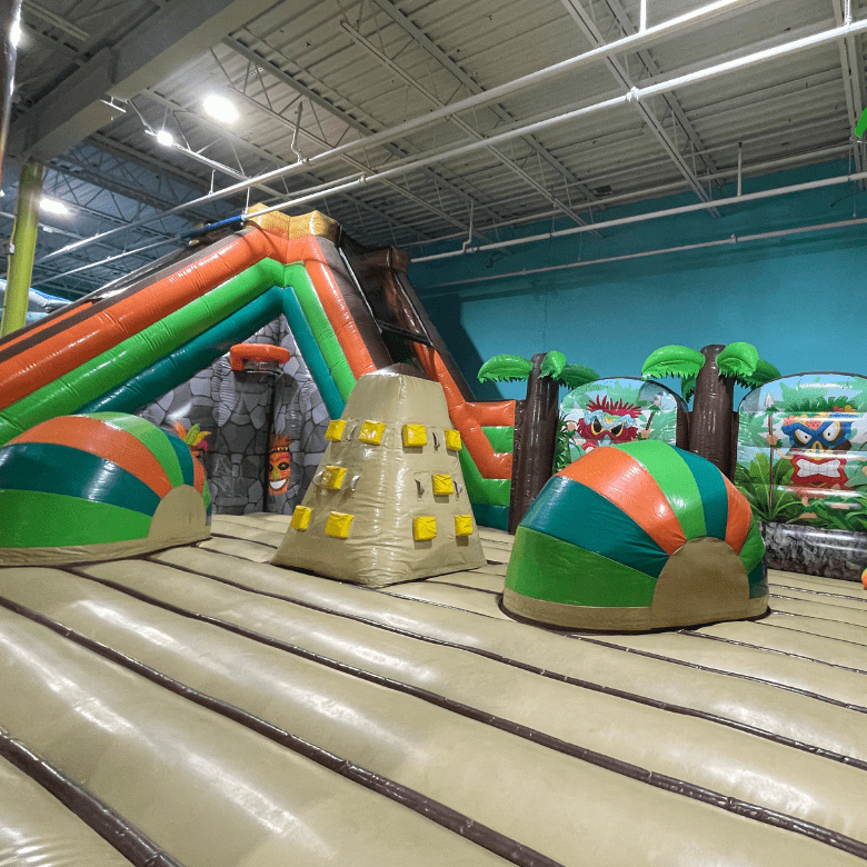 Colorful tiki themed inflatable playground in private party gym.