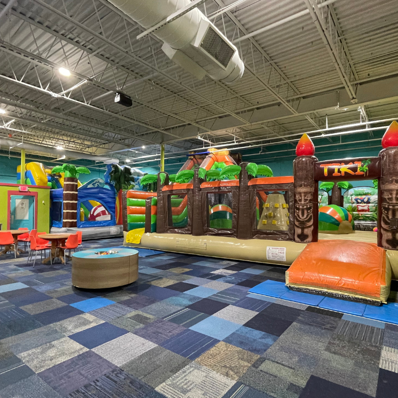 Colorful tiki themed inflatable playground in private party gym.