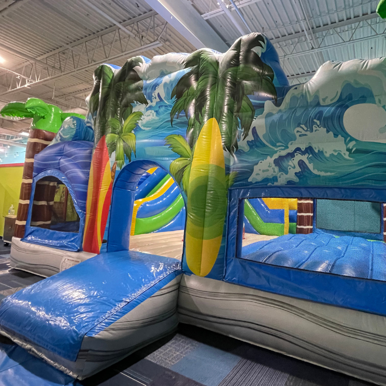 Colorful surf themed inflatable playground in private party gym.