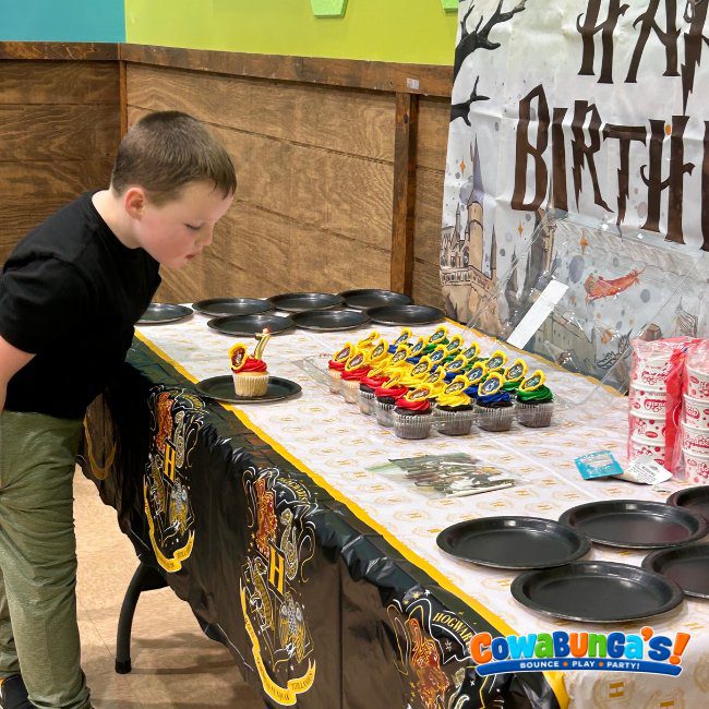 Birthday child beside a decorated cake table at Cowabunga’s Manchester, NH