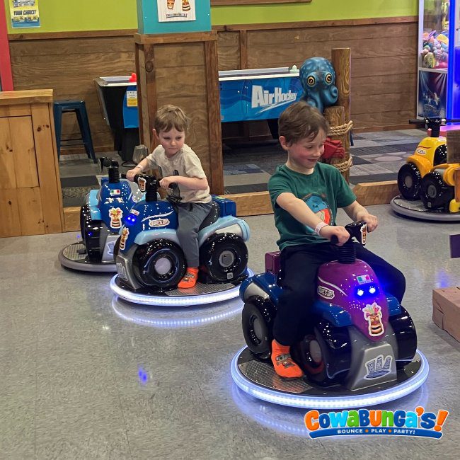 Children riding small play vehicles at Cowabunga’s Manchester, NH