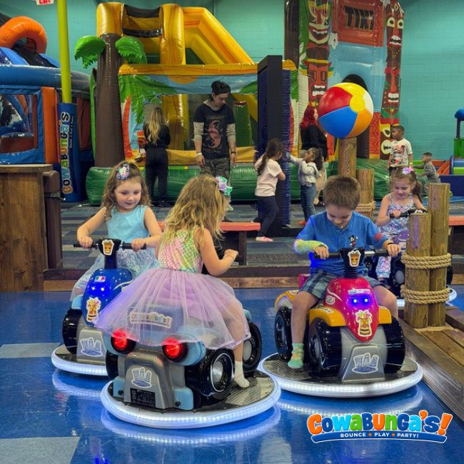 Children riding small play vehicles together at Cowabunga’s North Reading, MA